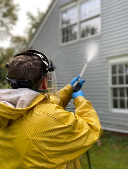 man power washing outside of house