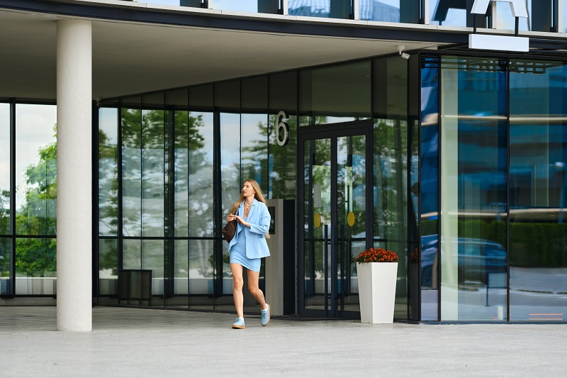 woman walking out of a modern building
